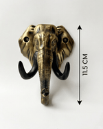 An antique gold elephant head key hook on a plain white background. A vertical double-sided arrow to the right marks its height measurement as