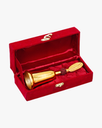 Gold-plated decorative bell with a red rudraksha bead and a leaf-shaped handle on top