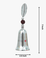 Silver-plated puja bell with rudraksha bead and decorative leaf handle used for Hindu prayer rituals.