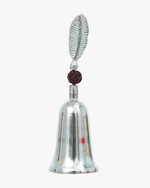 Silver-plated puja bell with rudraksha bead and decorative leaf handle used for Hindu prayer rituals.