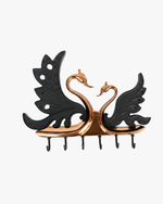 Decorative swan couple metal wall key holder with multiple hooks holding house and car keys.