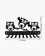 Black metal owl wall hook rack with three owls perched on a branch, shown with dimension labels indicating 10 inches wide and 5.5 inches tall on a light gray background.