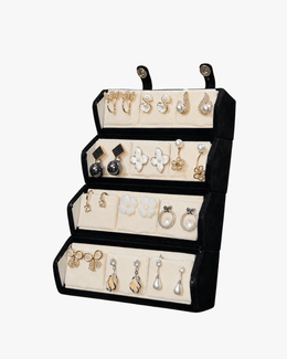 A black velvet multi-tier jewelry organizer stand holding various gold, silver, and pearl stud earrings, shown against a plain white background.
