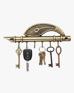 Antique brass-finished flute-shaped key holder with 6 hooks, showing various keys hanging for scale