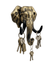 An antique gold-finished elephant head key holder set against a solid black background. Multiple sets of keys on rings hang from its black tusks and the tip of its curled trunk