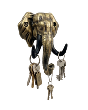 An antique gold-finished elephant head key holder set against a solid black background. Multiple sets of keys on rings hang from its black tusks and the tip of its curled trunk
