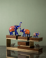Close-up of a large royal blue metal elephant statue featuring hand-painted red floral patterns and gold accents