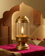 Brass Akhand diya with glass cover placed on a red cloth with decorative background arch
