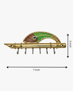 Brass flute wall key holder with peacock feather motif showing 7 inch width and 3 inch height