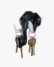 Angled view of elephant wall key holder showing keys hanging on tusk-shaped hooks
