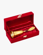 Gold plated rudraksha pooja bell placed inside red velvet gift box