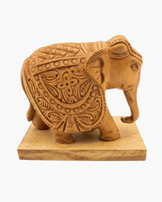 Hand carved wooden elephant figurine featuring traditional floral motifs and solid base