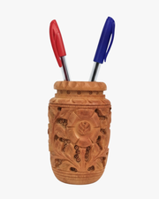 Hand carved wooden pen stand holder with floral design holding pens on desk