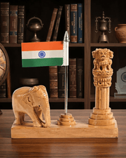 Close-up view of handcarved wooden Ashok Stambh pillar, Indian national flag, and elephant figurine placed on a study table.