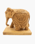 Handcrafted wooden elephant statue with intricate carvings side view on wooden base