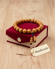 Handmade Chandan Bracelet made from natural sandalwood beads with elastic band displayed beside a red gift box, ideal for daily wear and gifting.