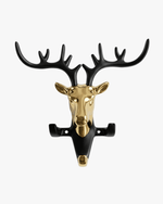 Front view of a luxury matte black deer head wall hook with polished gold antlers and a three-hook design