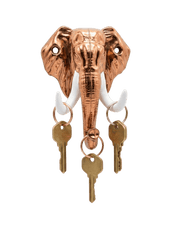 A shiny copper-colored elephant head key holder against a black background. It features contrasting white tusks with several single brass keys hanging from keyrings on each tusk and the trunk
