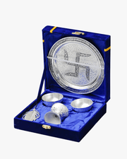 Open blue velvet gift box showing silver pooja thali set with diya bowls and feather spoon