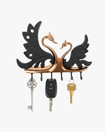 Decorative swan couple metal wall key holder with multiple hooks holding house and car keys.