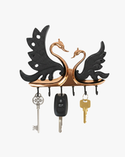 Decorative swan couple metal wall key holder with multiple hooks holding house and car keys.
