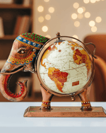 Hand-painted metal elephant globe decor measuring 25.5 cm in length and 19 cm in height, featuring a rotating world map and ethnic gemstone-style embellishments