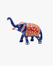 Three decorative blue Meenakari elephants styled on a modern gold and wood console table in a luxury living room