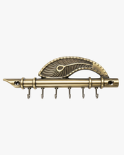 Front view of a vintage metal key holder designed as a flute with an ornate peacock feather accent